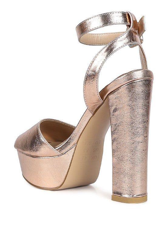 Rose gold platform high heel sandal with ankle strap, metallic finish, isolated on white