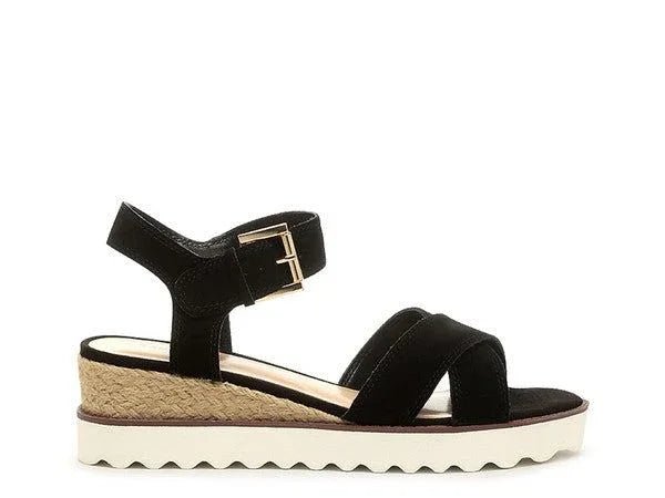 Black suede wedge sandal with ankle strap, gold buckle, jute trim, and white platform sole