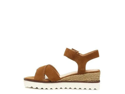 Brown suede wedge sandal with ankle strap and white sole on white background