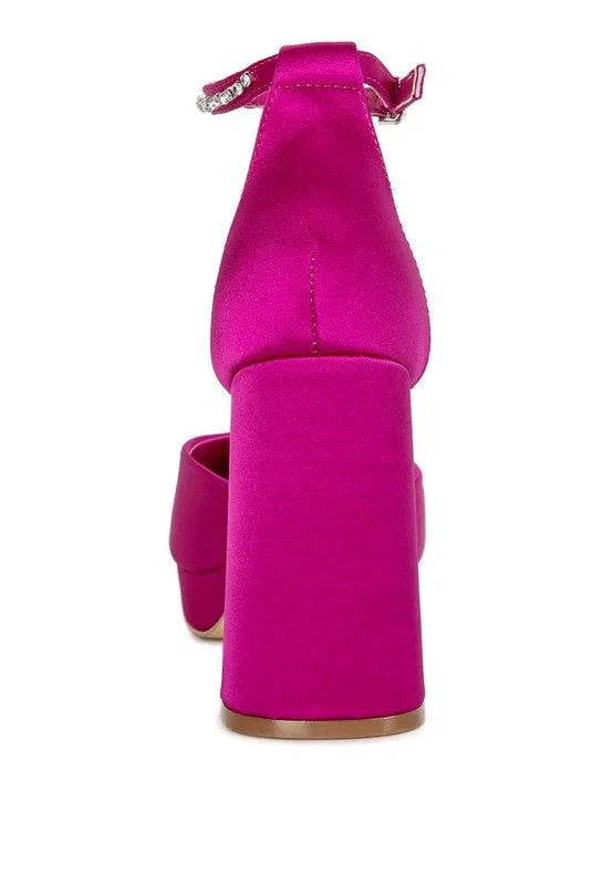 Back view of a bright pink block heel sandal with ankle strap on white background