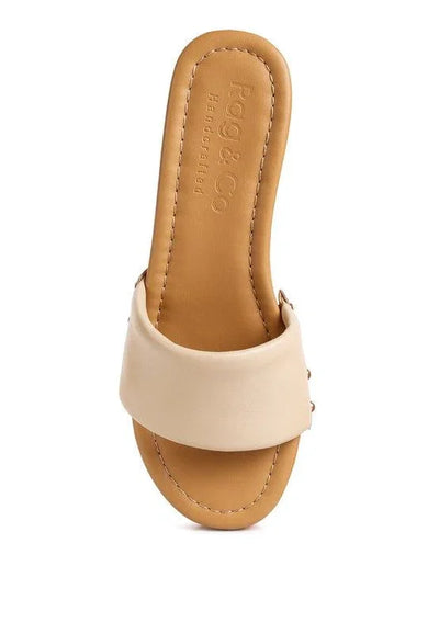 Beige handcrafted slide sandal with wide leather strap on white background