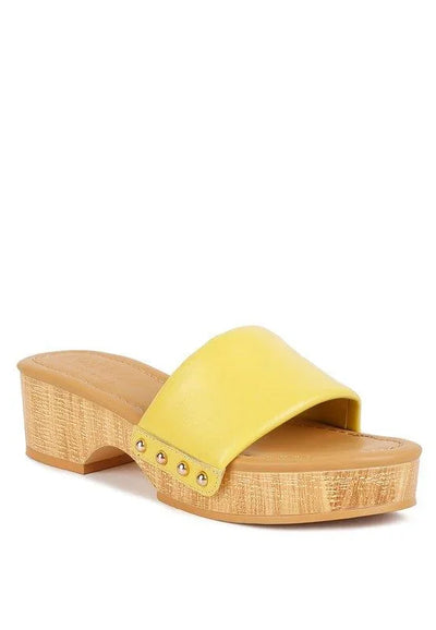 Yellow slide sandal with wood platform sole and gold rivet accents