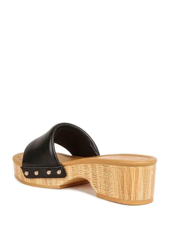 Black slide sandal with studded trim and wood-textured block heel on white background