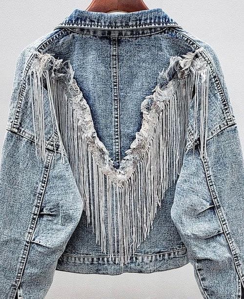Light blue denim jacket with V-shaped fringe and distressed details on the back.