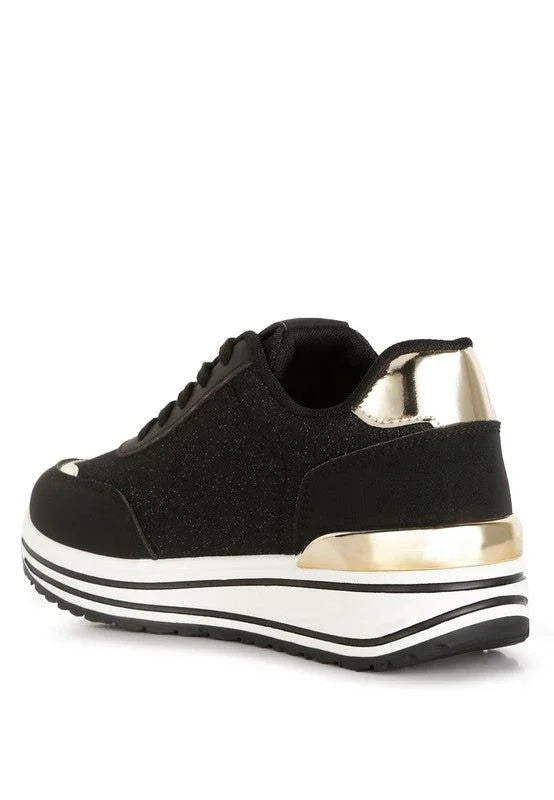 Black sneaker with gold metallic heel and platform sole on white background