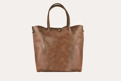 Brown leather tote bag with dual handles on white background