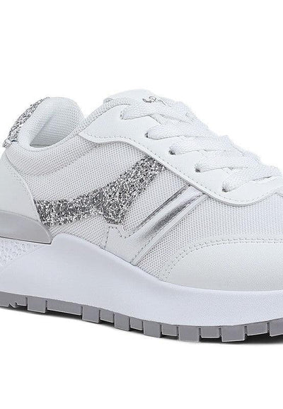 White sneaker with silver glitter accents and textured sole, side view