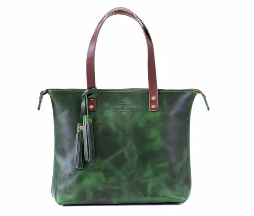 Emerald green leather tote bag with brown handles and tassel, front view on white background