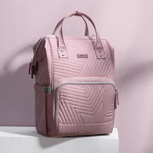 Pink quilted backpack with front zipper pocket on a light pink background