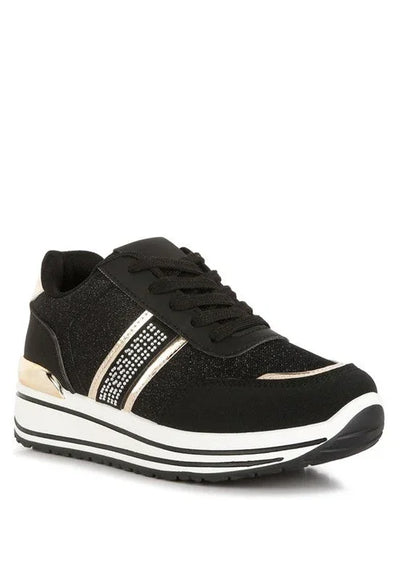 Black platform sneaker with gold accents, rhinestone stripes, and white sole