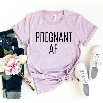 Pink 'Pregnant AF' maternity t-shirt with jeans, white sneakers, and peony flowers flat lay