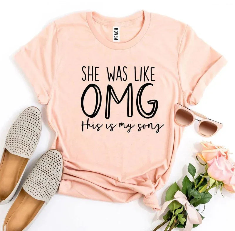 Peach graphic tee with 'She was like OMG this is my song,' sunglasses, flats, roses