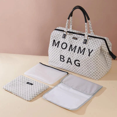 Large white patterned mommy bag with black handles and three matching pouches on beige surface