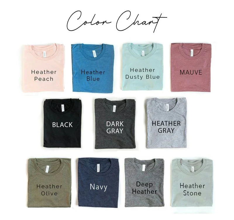 T-shirt color chart with 11 folded shirts labeled Heather Peach, Heather Blue, Heather Dusty Blue, Mauve, Black, Dark Gray, Heather Gray, Heather Olive, Navy, Deep Heather, and Heather Stone.