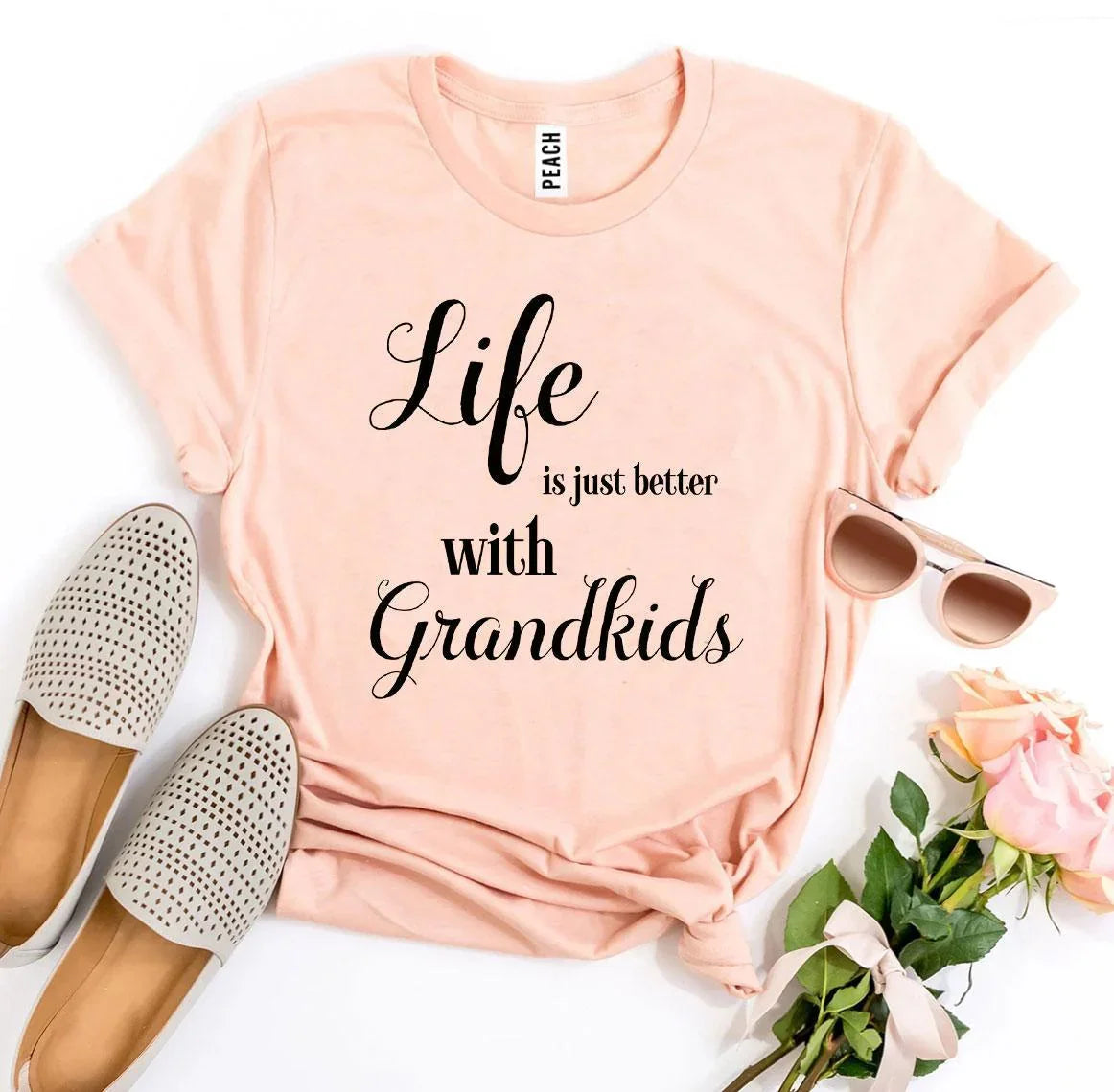 Peach t-shirt with 'Life is just better with Grandkids' text, flats, sunglasses, roses