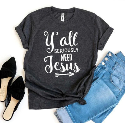 Dark gray graphic t-shirt with 'Y'all Seriously Need Jesus' text, jeans, and black shoes