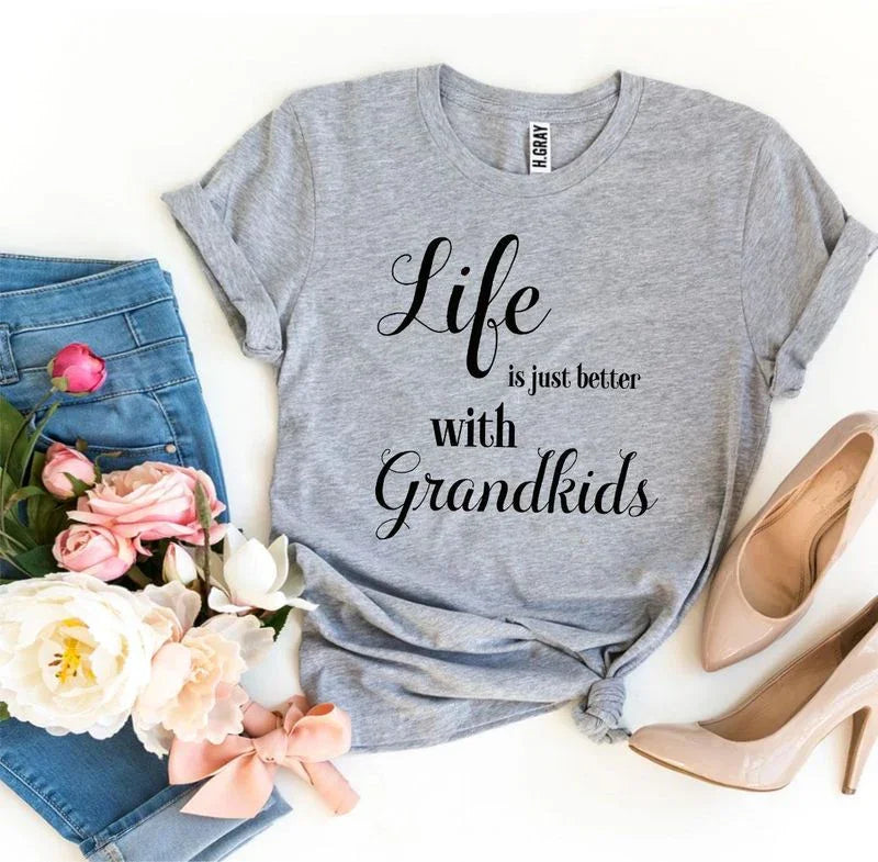 Gray t-shirt with 'Life is just better with Grandkids' text, blue jeans, flowers, nude heels