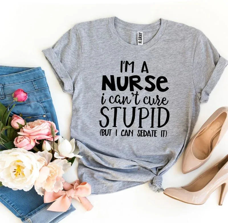 Gray nurse quote t-shirt styled with jeans, flowers, and nude heels on white background