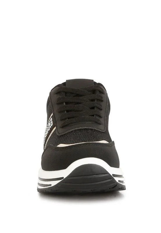 Front view of black sneaker with white sole and rhinestone side detail, on white background