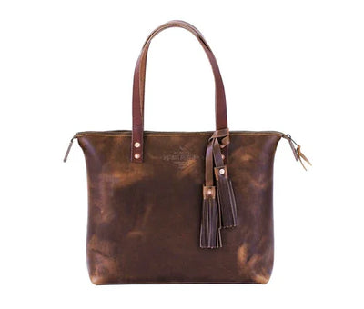 Brown leather tote bag with long handles and decorative tassels, minimalist design